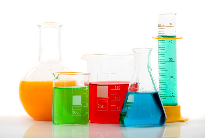 chemistry bottles with different colour liquid inside over a white background