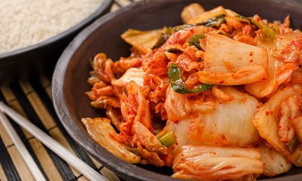 A bowl of traditional Korean napa kimchi with white rice.